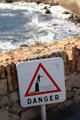 Warning sign about risk of falling off ramparts into sea. Antibes, France.