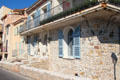 Rough-hewn stone house with iron balcony in Old Antibes. Antibes, France.