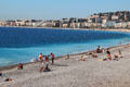 Sunbathers on beach facing Bay of Angers along Promenade des Anglais. Nice, France.