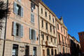 Older buildings with shops, cafés & residences lining harbor. St Tropez, France.