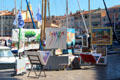 Display of artist's work along harbor. St Tropez, France.