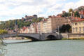 Quai Fulchiron streetscape of heritage buildings over Bonaparte bridge on Saône River. Lyon, France.