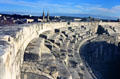 Arena upper tier of seats with town beyond. Nimes, France.