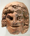 Roman terracotta roof antefix with comedic theater mask at Musée de la Romanité. Nimes, France.