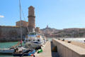 Fanal tower at mouth of Marseille harbor with Basilique Notre-Dame de la Garde beyond. Marseille, France.