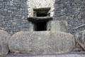 Passage tomb entrance guarded by Megalithic-carved swirl at Newgrange. Ireland.