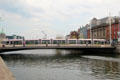 Tram crosses Rosie Hackett Bridge over River Liffey. Dublin, Ireland.