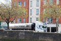 Guinness tanker truck drives south bank of River Liffey. Dublin, Ireland.
