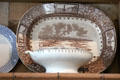 Brown ceramic plate printed with town scene & shamrocks at Strokestown Park. Vesnoy, Ireland.