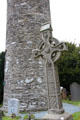 Celtic cross at base of round tower at Glendalough. Ireland