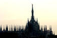 Duomo dome & spires in against morning sun. Milan, Italy.