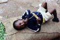 Young boy relaxing on a bag of beans in a market near Nairobi. Kenya.