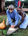 Tourist learns to grind maize in Riyuki Cultural Center. Kenya.