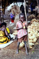 Child amongst vendors stalls of Malindi market. Kenya.