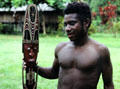 Carver posing with his artwork near the house Tambaran in Wambun. Papua New Guinea