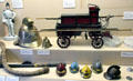 Model firemen's helmets & objects plus model fire pumper at Museum of Edinburgh. Edinburgh, Scotland.