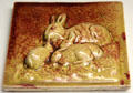 Earthenware tile with rabbits of yellow & red glazes by Dunmore Pottery at Museum of Edinburgh. Edinburgh, Scotland.