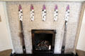 C.R. Mackintosh designed glass-mosaic petals inset into small tile surface of fireplace supporting architects steel fire-irons in drawing room at Hill House. Helensburgh, Scotland.
