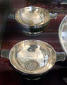 Pair of silver quaiches each embedded with coin from the 1500s at Abbotsford House. Melrose, Scotland.