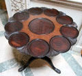 Round table with inserted circular sections divided by carved ginkgo leaves at Manderston House. Duns, Scotland