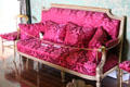 French Empire style red damask sofa in large drawing room at Thirlestane Castle. Scotland.