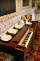 Piano in dining room under wallpaper purchased at Great Exhibition at Traquair House. Scotland.