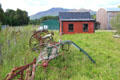 Horse-drawn harvesting machines with red railway waiting room beyond at Highland Folk Museum. Newtonmore, Scotland.