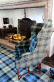 Armchair in front of The Hall fireplace decorated in Forbes tartan at Craigievar Castle. Alford, Scotland.