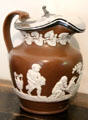 Brown ceramic pitcher with white classical figures & hinged metal lid at Crathes Castle. Crathes, Scotland.