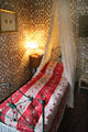 Governess room with canopy bed & fake wallpaper stencilled with paint at Castle Fraser. Aberdeenshire, Scotland.