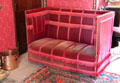 Red upholstered settle in library at Fyvie Castle. Turriff, Scotland.