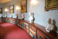 Curved hallway lined with paintings, bust & books at Haddo House. Methlick, Scotland.