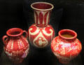 Three art pottery vases painted lustre red by Walter Crane for Maw & Co at Jackfield Tile Museum. Ironbridge, England.