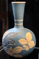 Salopian bottle vase incised with bird & bramble on light bluebackground by Benthall Pottery at Jackfield Tile Museum. Ironbridge, England.