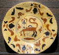 Slip decorated dish with crowned lion by potter with initials IG made in North Straffordshire at Potteries Museum & Art Gallery. Hanley, Stoke-on-Trent, England.
