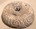 Stone beehive quern used to grind cereal grains with Celtic spiral decoration at Ulster Museum. Belfast, Northern Ireland.