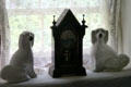 Pair of ceramic King Charles Spaniels flanking mantle clock in weavers cottage at Ulster American Folk Park. Omagh, Northern Ireland.