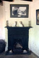 Fireplace with pair of ceramic King Charles Spaniels plus candlesticks at Mellon Homestead at Ulster American Folk Park. Omagh, Northern Ireland.