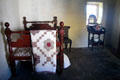 Bed with coverlet & wash stand in Mellon Homestead at Ulster American Folk Park. Omagh, Northern Ireland.
