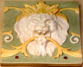 Earthenware tile with lion mask by Minton & Co of Stoke-on-Trent at British Museum. London, United Kingdom.