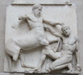 Centaur tramples a falling Lapith who reaches for a stone in defense marble metope section of Athens Parthenon Frieze by Pheidias at British Museum. London, United Kingdom.