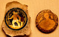 Roman glass disks with gold images of gladiator & beardless man from Rome at British Museum. London, United Kingdom.