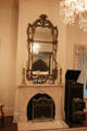 Bedroom fireplace with mirror framed in twisted branch design at Bragg-Mitchell Mansion. Mobile, AL.