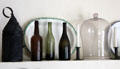 Lamp, bottles, plates & bell jar on kitchen mantle at Conde-Charlotte Museum. Mobile, AL.