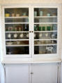 Pantry cupboard with dishes at Clinton Birthplace Home. Hope, AR.
