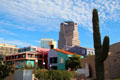 Colorful buildings of La Placita complex with highrise Tucson skyline beyond. Tucson, AZ.