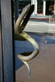 Bronze snake door handle slithers through glass door on Rodeo Drive store. Beverly Hills, CA.