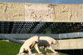 Reliefs of ancient life around La Brea Tar Pits on facade of Page Museum of La Brea Discoveries above Saber Tooth Tiger sculptures. Los Angeles, CA.