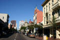 Heritage buildings along 5th Ave. of Gaslamp Quarter with highrises of downtown beyond. San Diego, CA.
