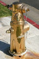 Polished brass fireplug as memorial to firefighters who died on 9/11 in front of Fire Station. Oceanside, CA.